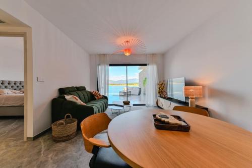 a living room with a table and a couch at Le Galatée ,T2 luxe pieds dans l'eau in Porticcio