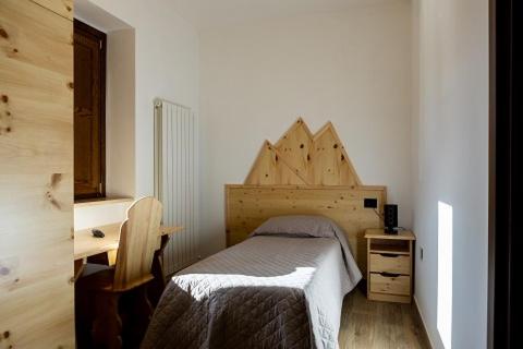 um pequeno quarto com uma cama e uma secretária em La Villetta Food & Drink Rooms for Rent - No Reception - em LʼAquila