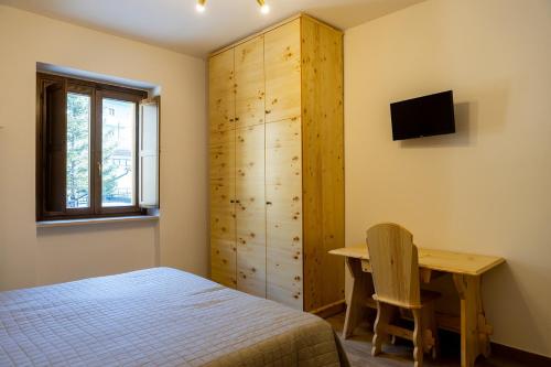 a bedroom with a bed and a desk and a cabinet at La Villetta Food & Drink Rooms for Rent - No Reception - in LʼAquila