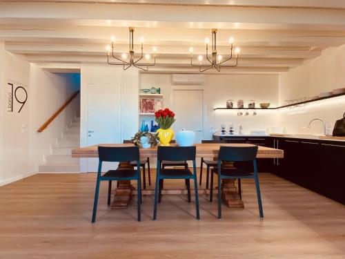 Il comprend une cuisine et une salle à manger avec une table et des chaises en bois. dans l'établissement Residence19ilborgo, à Asolo