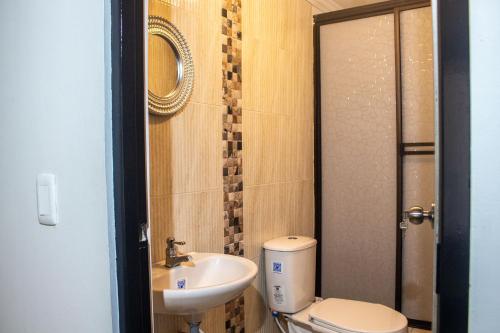 a small bathroom with a toilet and a sink at Casa hotel las gaviotas II in Santa Marta