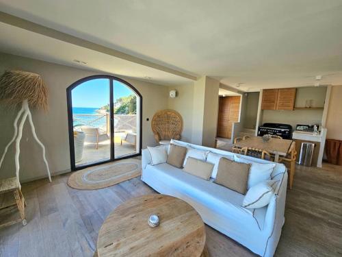 un salon avec un canapé et une table dans l'établissement Villa prestige au bord de l'eau- Misincu, à Cagnano