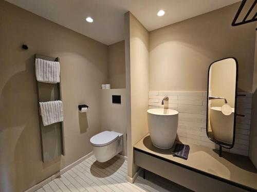 a bathroom with a toilet and a large mirror at Villa prestige au bord de l'eau- Misincu in Cagnano