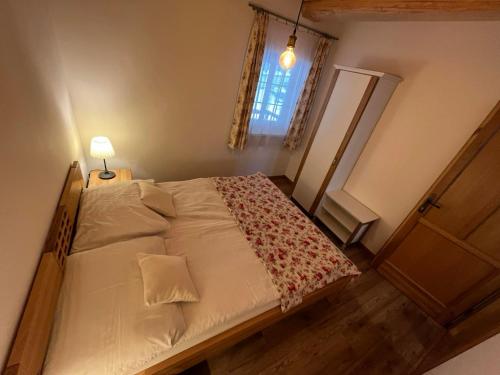 a small bedroom with a bed with a window at Penzión Skorušina in Brezovica
