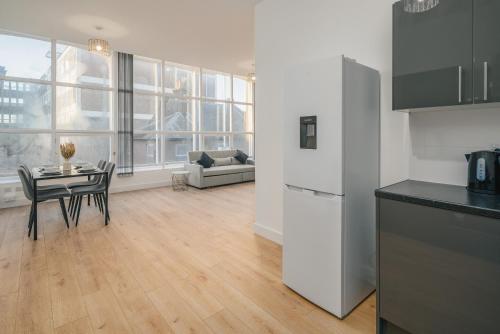 a kitchen and living room with a table and a refrigerator at Contractors I Working professionals I Relocators - Near Train Station and Airport in Luton