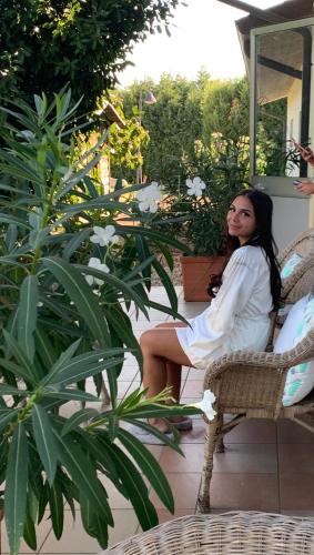 a woman sitting in a chair on a patio at B&B Beauty House in Cesena