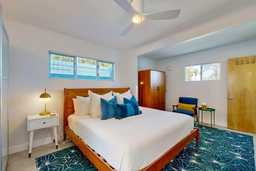 een slaapkamer met een groot wit bed met blauwe kussens bij The Aluminum House Permit# 2227 in Palm Springs