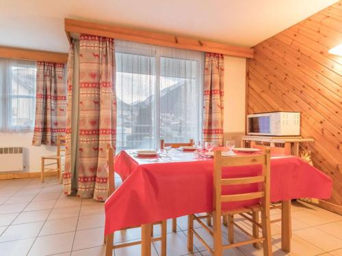 une salle à manger avec une table et des chaises rouges dans l'établissement Appartement 3 pièces, 4-6 pers, centre Briançon, balcon, garage, à 400m télécabine - FR-1-330C-14, à Briançon