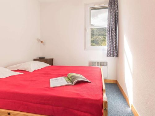 a bedroom with a red bed with a book on it at Appartement Briançon, 3 pièces, 6 personnes - FR-1-330C-14 in Briançon