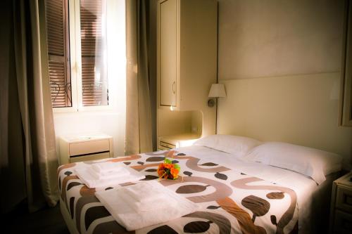 een slaapkamer met een bed met een bloemstuk erop bij St. Peter Central Rooms B&B in Rome