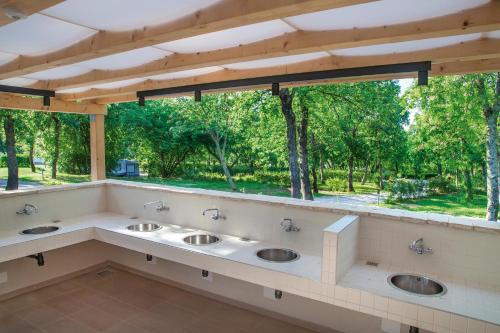 łazienka z 3 umywalkami i dużym oknem w obiekcie Istra Sunny Tent in Lanterna Premium Camping Resort 4* w Poreču