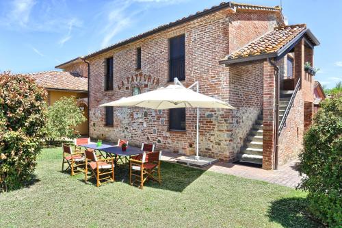 einen Tisch und Stühle mit Sonnenschirm im Hof in der Unterkunft Agriturismo La Fattoria in Panicarola