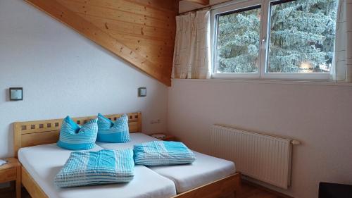 ナウダースにあるHaus Patscheiderのベッドルーム1室(青い枕のベッド1台付)