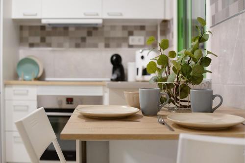 una cocina con una mesa con platos y una planta en Casa David Prieto 2 Habitaciones, en Caleta de Fuste