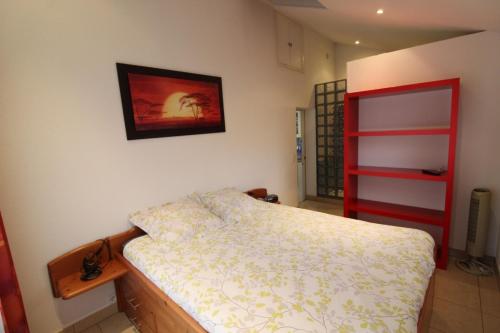 sypialnia z łóżkiem i obrazem na ścianie w obiekcie Le Parigney 