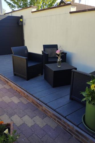 a patio with chairs and a table with a vase of flowers at Le Parigney in Igney