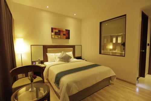a bedroom with a bed and a table and a mirror at Park Connect in Cochin