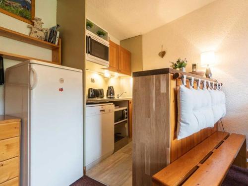uma pequena cozinha com um banco e um frigorífico em Appartement Valmorel, 3 pièces, 4 personnes - FR-1-291-852 em Valmorel