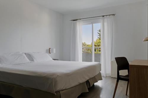 a bedroom with a bed and a window and a desk at Prinsotel Mal Pas - Adults Only in Alcudia