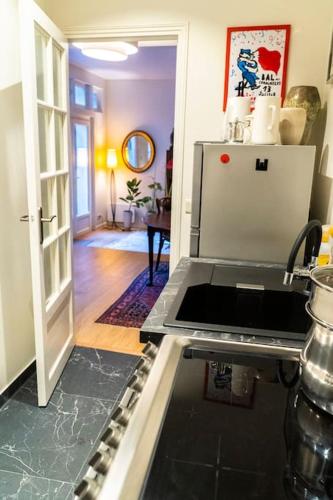 - une cuisine avec une cuisinière et une porte ouverte dans l'établissement Cosy Apartment in Paris, à Paris