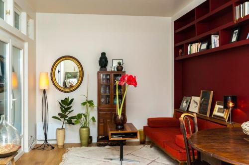 un salon avec un canapé rouge et un miroir dans l'établissement Cosy Apartment in Paris, à Paris