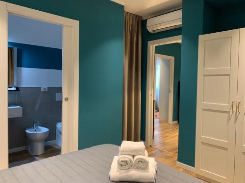 a bedroom with blue walls and a bed with two towels at Apartment Hotel Marchesini in Ravenna