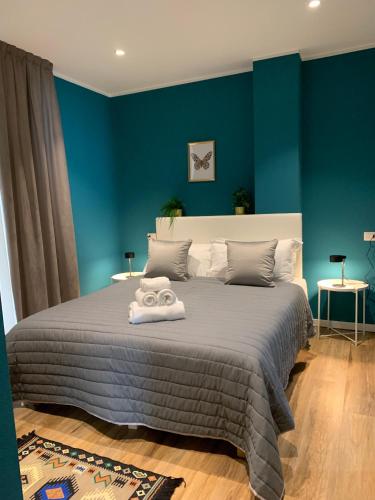 a bedroom with a large bed with blue walls at Apartment Hotel Marchesini in Ravenna