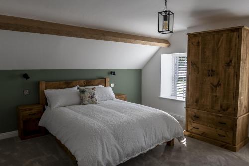 a bedroom with a large bed and a wooden cabinet at Pen Isa’r Llan in Bala