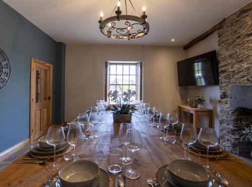 a dining room with a long table with wine glasses at Pen Isa’r Llan in Bala