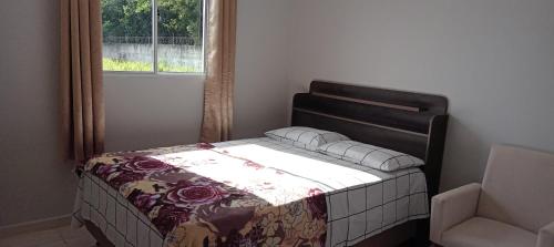 uma cama num quarto com uma janela em Bananeiras locações por temporada e acomodações em Bananeiras