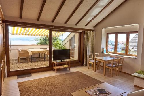een woonkamer met een televisie en een eetkamer met een tafel bij Bodenseeblick in Konstanz