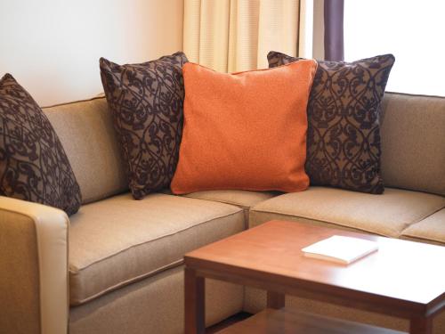 a living room with a couch with pillows and a table at Best Western Plus Milford Hotel in South Milford
