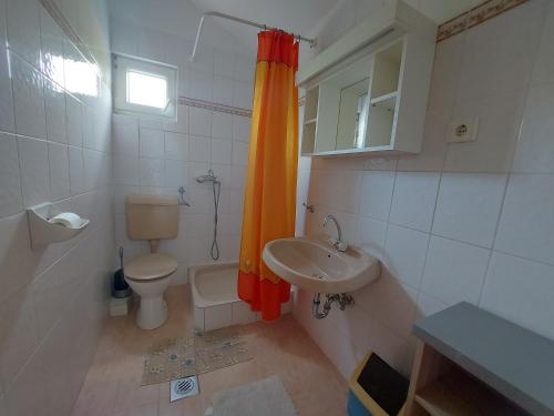 La petite salle de bains est pourvue de toilettes et d'un lavabo. dans l'établissement Krisztina-Rózsa ház, à Balatonföldvár