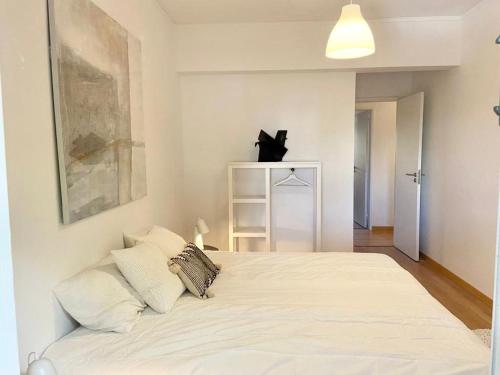 a bedroom with a bed with white sheets and pillows at Charming 3 Bedroom Apartment in the centre of Faro in Faro