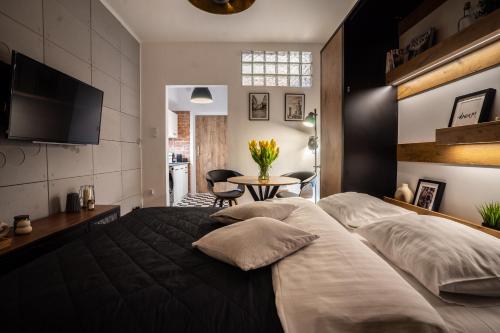 a bedroom with a large bed and a table at Old Town Heart XII - Poznańska Luxury Loft in Warsaw
