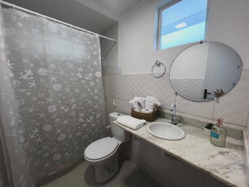 a bathroom with a toilet and a sink and a mirror at Sam Day Suites in Natal