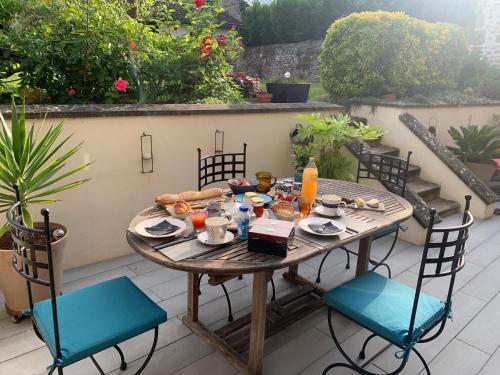 ein Holztisch und Stühle auf einer Terrasse in der Unterkunft La maison d'Hélios in Alençon