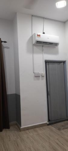 a room with a white wall and a door at Kayangan Apartment in Kangar