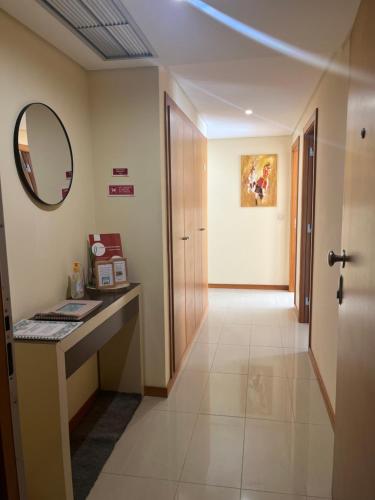 a hallway with a desk and a mirror and a door at Lovely&Charming Anita’s apartment in Ponta Delgada