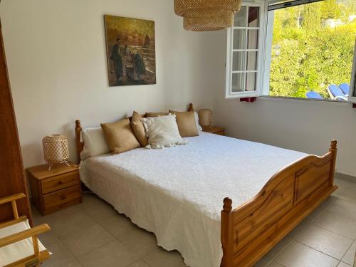 ein Schlafzimmer mit einem großen Bett mit Fenster in der Unterkunft Villa Alexandra in La Croix-Valmer