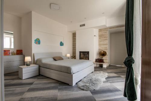ein weißes Schlafzimmer mit einem Bett und einem Kamin in der Unterkunft Casa del Rosmarino in Asti