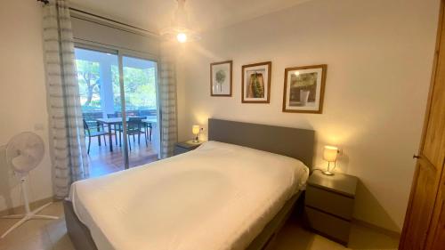 a bedroom with a bed and a table and a window at Apartamento en Pinar de la Cala - D in L'Ametlla de Mar