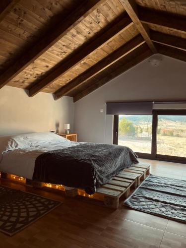 um quarto com uma cama e uma grande janela em Polar chalet em Kalívia