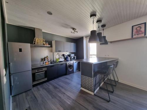 cocina con armarios azules y encimera en Le Claussat - Hypercentre - Parking - Wifi, en Chamalières