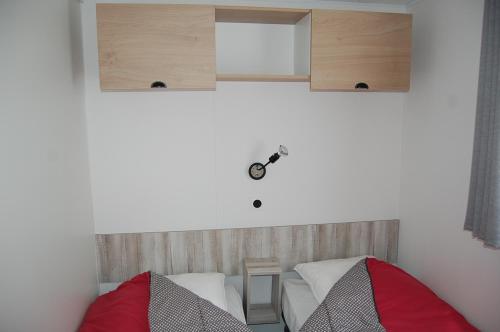 1 dormitorio con 1 cama y armarios en la pared en Camping Les Clarines en La Bourboule