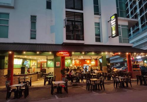 a restaurant with tables and chairs in front of a building at LV Homestay @ Gala Residence in Kuching