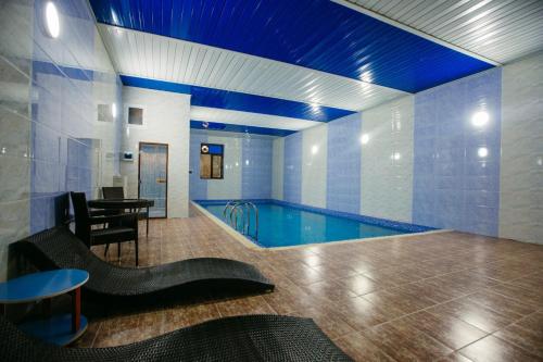 GRAND HOTEL SOGDIANA في سمرقند: مسبح كبير مع طاولة وغرفة طعام