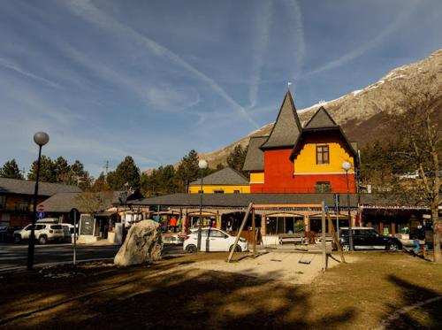 a yellow and orange building with cars parked in a parking lot at La Villetta Food & Drink Rooms for Rent - No Reception - in LʼAquila