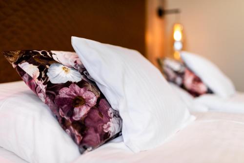 a pillow with a flower pattern sits on a bed at Hotel Spahr in Stuttgart