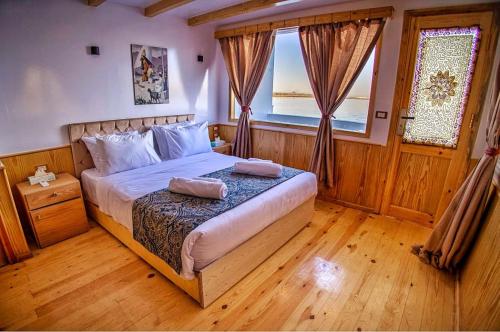 a bedroom with a bed with two pillows on it at Dahabiya Akhnaton Every Monday from Esna to Aswan for 4 Nights in Luxor